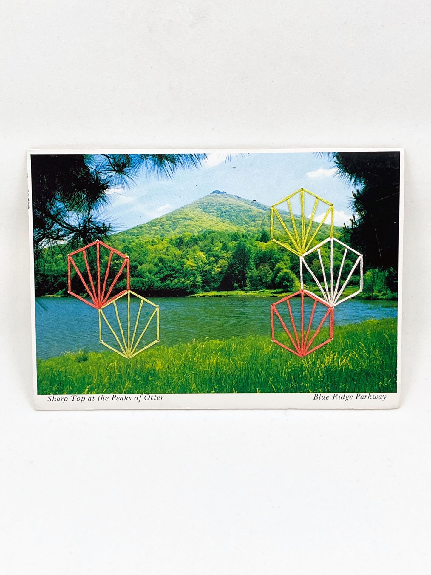 vintage postcard of a peak in the Blue Ridge Mountains, hand embroidered over with Art Deco style hexagons in coral chartreuse and peach